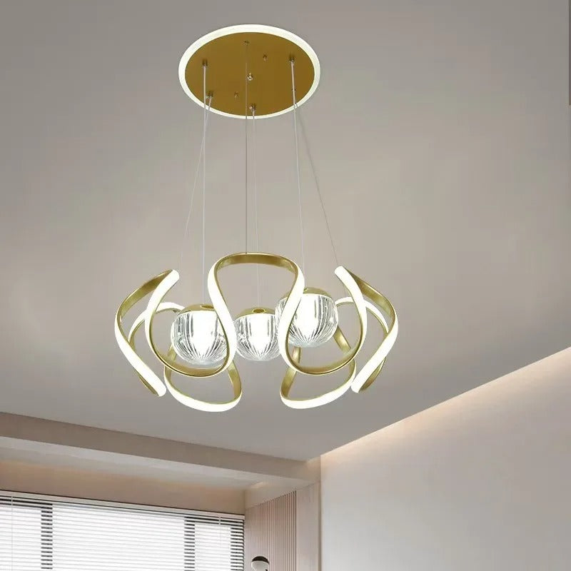 Gold-colored pendant lamp with curved frames and glass spheres